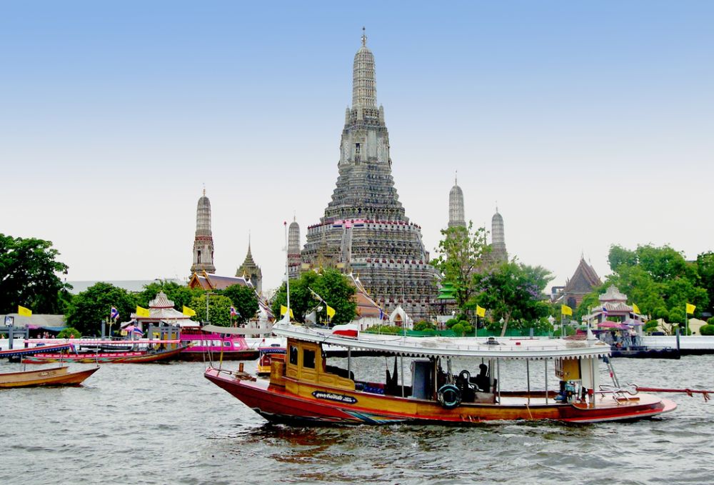 Barche sul fiume Chao Phraya davanti al tempio Wat Arun, Bangkok