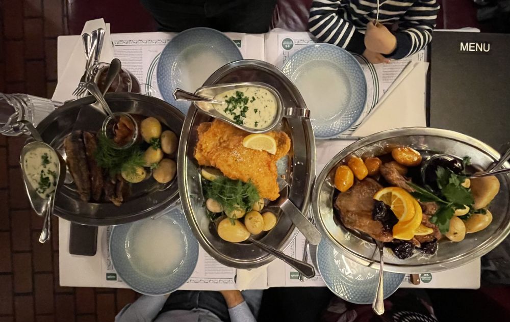 Piatti tipici danesi al Det Lille Apotek: da sinistra anatra arrosto, fish & chips danese, aringa fritta, accompagnati da patate bollite e salse