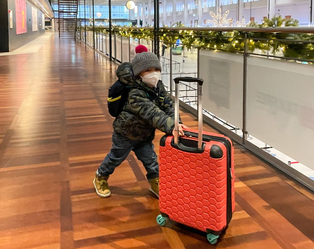 Figlio di Paola Bertoni all'aeroporto di Copenaghen con mascherina FFP2 e valigia trolley