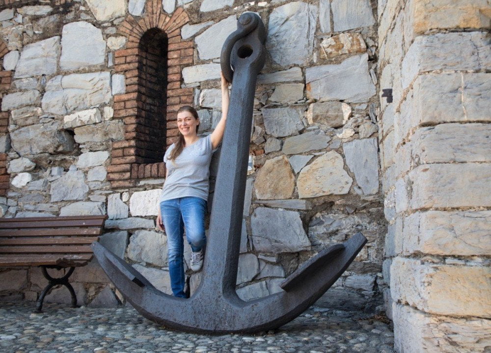 Paola Bertoni appoggiata a un'ancora all'ingresso della Lanterna di Genova