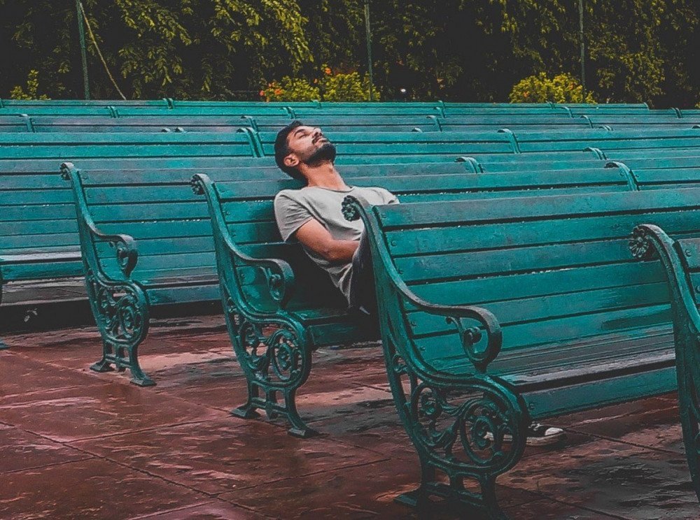 Ragazzo che dorme su una panchina